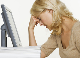 Frustrated Woman at Computer With Stack of Paper